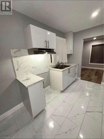 Ottawa apartment for rent - A kitchen with white cabinets and marble countertops.