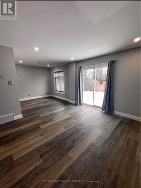 Ottawa apartment for rent - A room with wooden flooring and a sliding glass door.