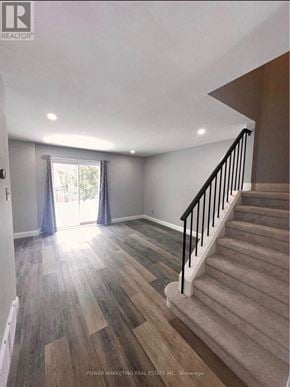 Ottawa apartment for rent - A staircase with a beige carpeted runner and a black railing.