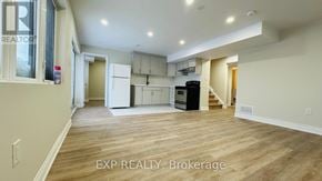 Kitchener apartment for rent - A spacious room with wooden flooring and a kitchen area in the background.