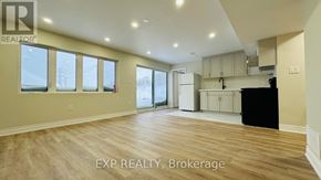 Kitchener apartment for rent - A spacious room with wooden flooring and large windows.