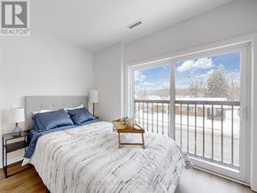 Kawartha Lakes (Lindsay) multi-family for rent - A bedroom with a large bed and a view of the outside.