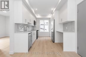 Ottawa multi-family for rent - A modern kitchen with white cabinets and stainless steel appliances.