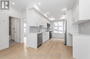 Ottawa multi-family for rent - A modern kitchen with white cabinets and stainless steel appliances.