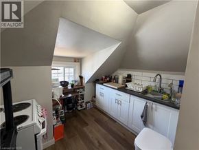 St. Catharines apartment for rent - A kitchen with white cabinets and a wooden floor.