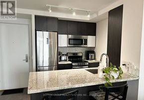 Toronto (Mimico) condo for rent - A modern kitchen with granite countertops and stainless steel appliances.