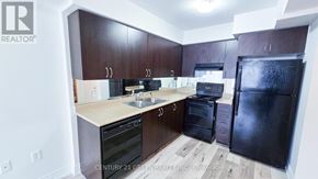 Markham (Greensborough) townhouse for rent - A kitchen with dark brown cabinets and black appliances.