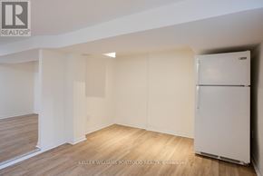 Toronto (Dovercourt-Wallace Emerson-Junction) apartment for rent - A white refrigerator is in a room with wood flooring and white walls.