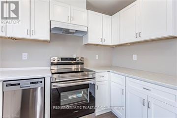 London East (East K) duplex for rent - A kitchen with white cabinets and stainless steel appliances.