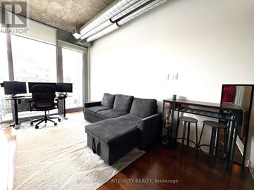 Ottawa condo for rent - A living room with a black couch and a black desk.
