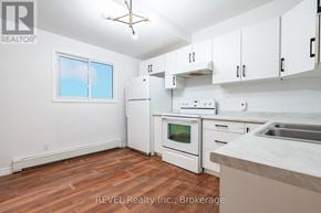 Niagara Falls (Downtown) triplex for rent - A kitchen with white appliances and cabinets.