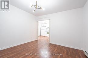 Niagara Falls (Downtown) triplex for rent - A room with a wooden floor and a white ceiling with a star-shaped light fixture.