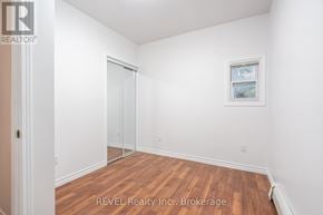 Niagara Falls (Downtown) triplex for rent - A room with a wooden floor and white walls, with a door and a window.