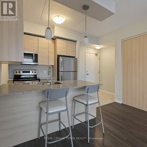 Waterloo condo for rent - A kitchen with a countertop, sink, and two chairs.