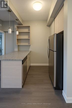 Waterloo condo for rent - A kitchen with a black refrigerator and a granite counter top.