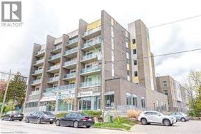 Waterloo condo for rent - A multi-story building with cars parked in front.