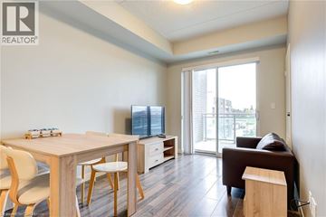 Waterloo condo for rent - A living room with a brown couch and a dining table with chairs.