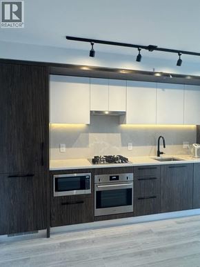 Vancouver apartment for rent - A modern kitchen with dark wood cabinets and stainless steel appliances.