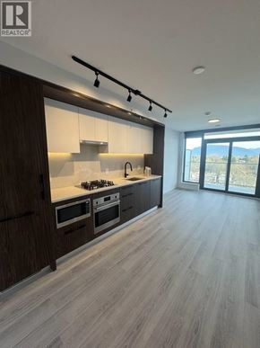 Vancouver apartment for rent - A modern kitchen with wooden cabinets and a stove top oven.
