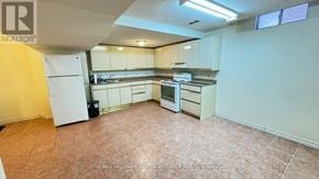 Richmond Hill (Doncrest) apartment for rent - A kitchen with white appliances and brown tile flooring.