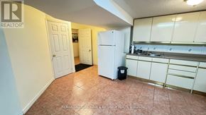 Richmond Hill (Doncrest) apartment for rent - A kitchen area with a refrigerator, cabinets, and a trash can.