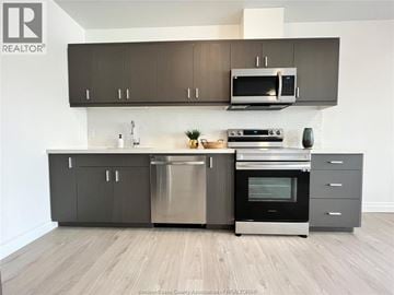 Lasalle condo for rent - A modern kitchen with a stainless steel dishwasher and oven.