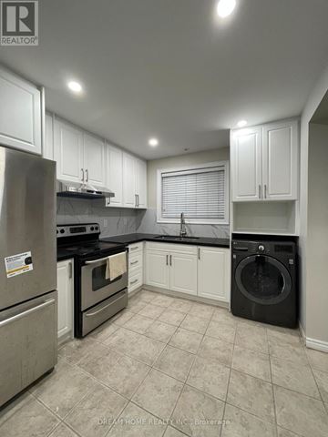 Toronto (Pleasant View) apartment for rent - A kitchen with white cabinets and black appliances.