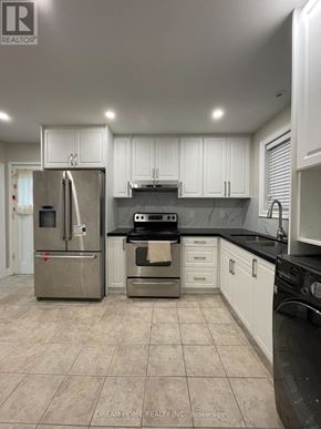 Toronto (Pleasant View) apartment for rent - A kitchen with white cabinets and a black countertop.