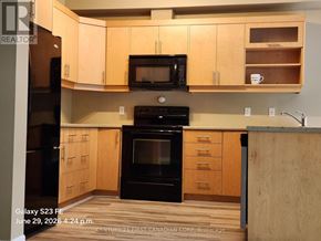 London North (North B) townhouse for rent - A hallway with a door on the right and a bedroom visible through the door.