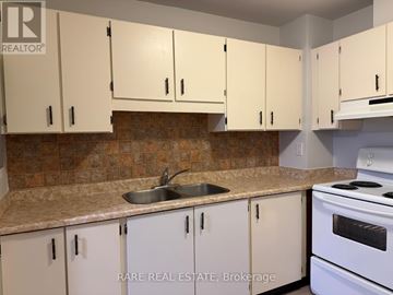 Orangeville condo for rent - A kitchen with white cabinets and a white stove.