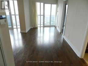 Mississauga (City Centre) condo for rent - A room with wooden floors and a view of the outside through the windows.