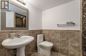 Kitchener apartment for rent - A bathroom with a sink, toilet and mirror.