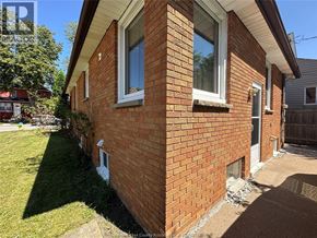Windsor apartment for rent - A red brick house with a white window and a door.