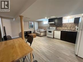 Windsor apartment for rent - A kitchen with a white fridge, white oven, and black cabinets.