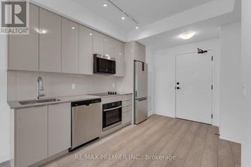 Vaughan (Concord) condo for rent - A modern kitchen with beige cabinets and stainless steel appliances.