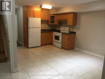 Toronto (Weston-Pellam Park) apartment for rent - A kitchen with white appliances and wooden cabinets.