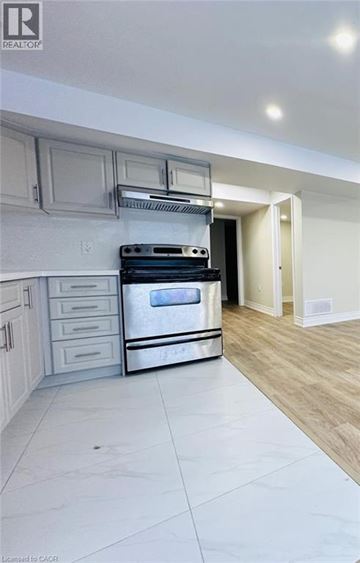 Kitchener apartment for rent - A modern kitchen with a stainless steel oven and white cabinets.