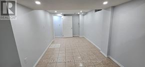 Brampton (Fletcher's West) apartment for rent - A spacious room with tiled flooring and white walls, with a door at the end.