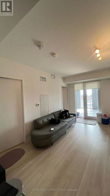 Toronto (Clanton Park) condo for rent - A living room with a grey sofa and wooden flooring.