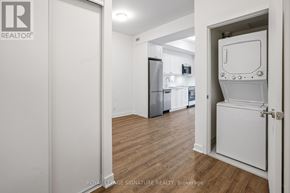 Clarington (Bowmanville) condo for rent - A white door is open to a kitchen with a fridge and a microwave.