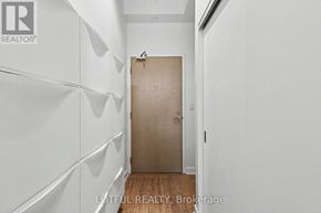 Ottawa condo for rent - A hallway with a wooden door and white walls.