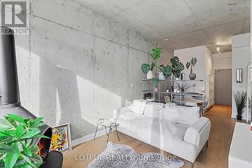 Ottawa condo for rent - A living room with a white couch and a grey rug.