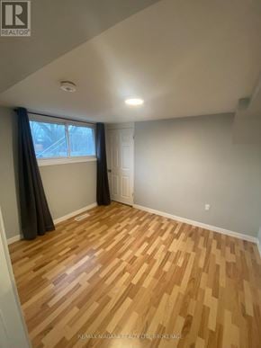 Welland (Prince Charles) multi-family for rent - A room with wooden flooring and a window with curtains.