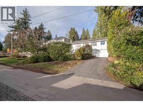 West Vancouver apartment for rent - A house with a driveway and a tree in front of it.