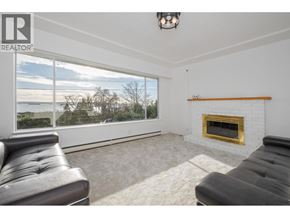 West Vancouver apartment for rent - A living room with a fireplace and a large window.