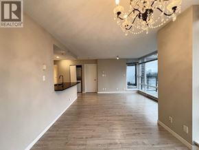 Coquitlam apartment for rent - A large, empty room with a chandelier and hardwood floors.