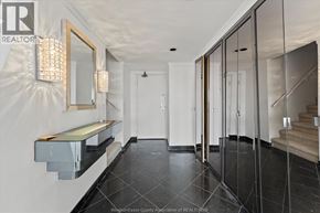 Windsor condo for rent - A hallway with a mirror, wall sconces, and a bench.