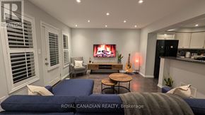 Brampton (Fletcher's West) townhouse for rent - A modern living room with a flat screen TV and a fireplace.