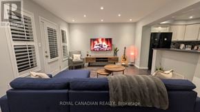 Brampton (Fletcher's West) townhouse for rent - A living room with a blue couch and a television on the wall.