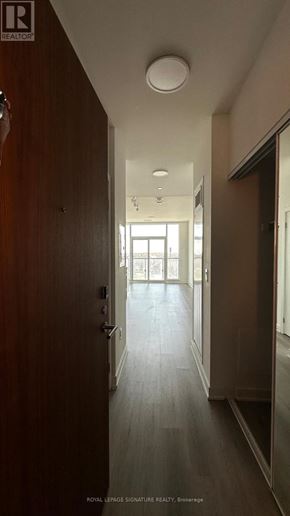 Brampton (Northwest Brampton) condo for rent - A long hallway with a door on the left and a window on the right.